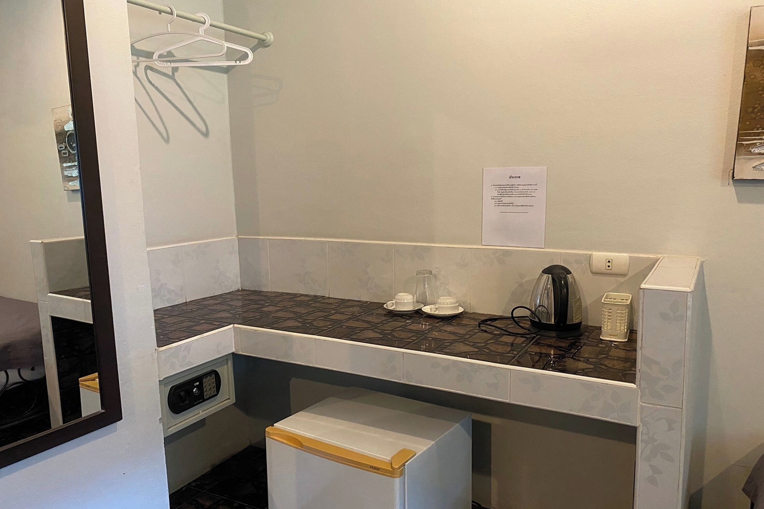 A compact bathroom with a sink, a mirror, a towel rack, and a small storage cabinet.