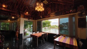 Un restaurant avec un plafond en bois, de grandes fenêtres et un lustre.