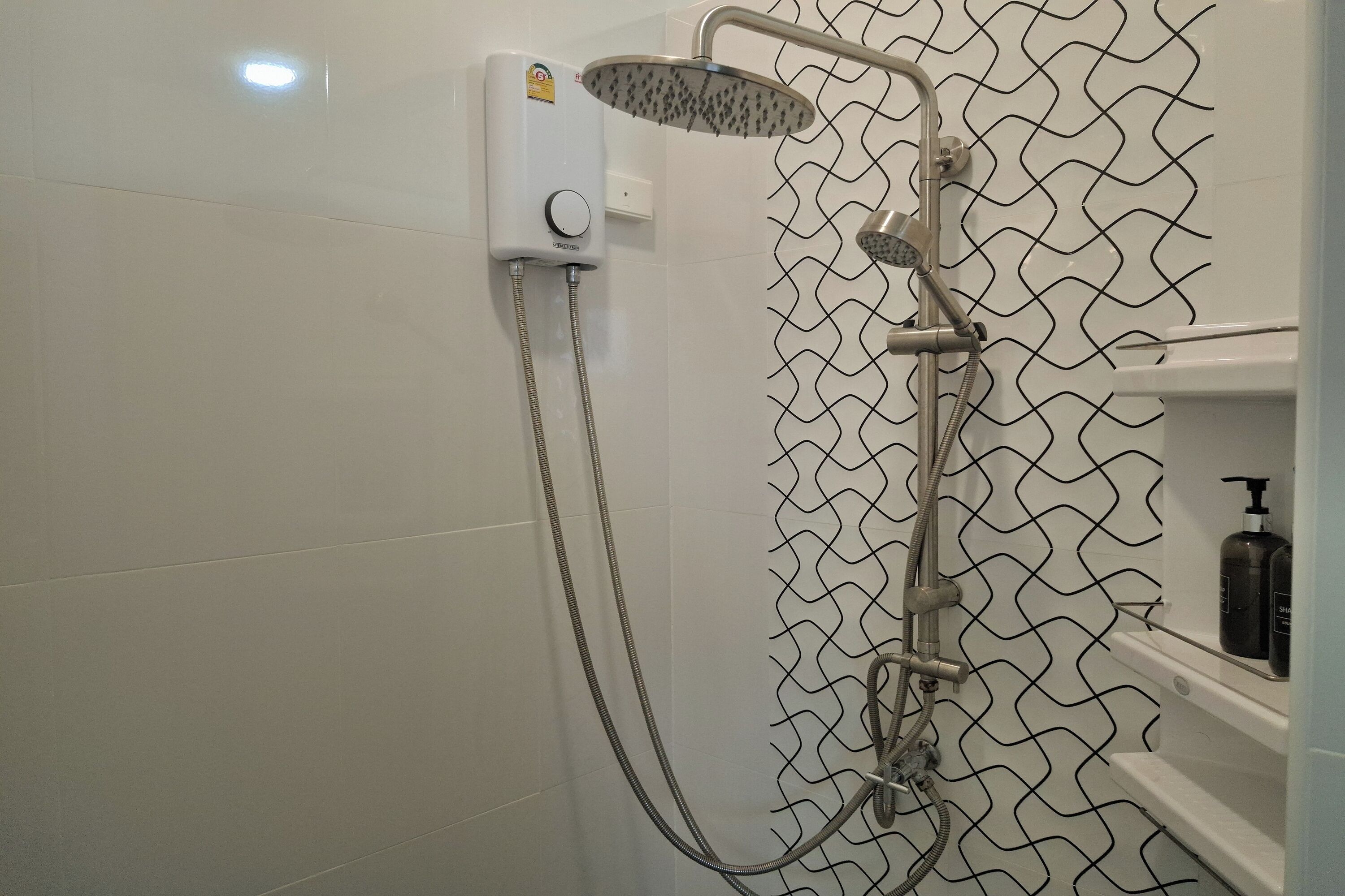 Chuveiro com chuveiro manual e painel de controle fixado na parede.