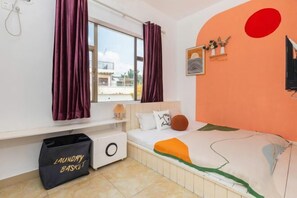 A bedroom with a bed, a window with curtains, a wall-mounted shelf with decorative items, and a laundry basket. - Shenzhen Shanhai Homestay (Jiaochangwei Dapeng Ancient City Branch) (Shenzhen)