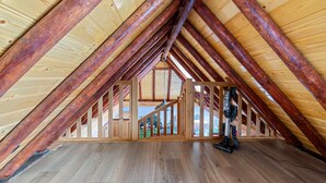 An attic room with wooden beams and a staircase leading to an upper level. - Detached Home in Friesland by Canal (Jistrum / Skûlenboarch)