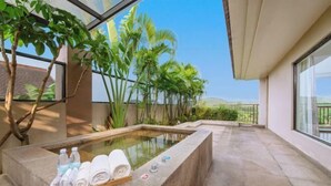 Een wellnessruimte met een jacuzzi, handdoeken en waterflesjes.