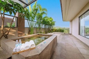 Ein Wellnessbereich mit Whirlpool, Handtüchern und Wasserflaschen.