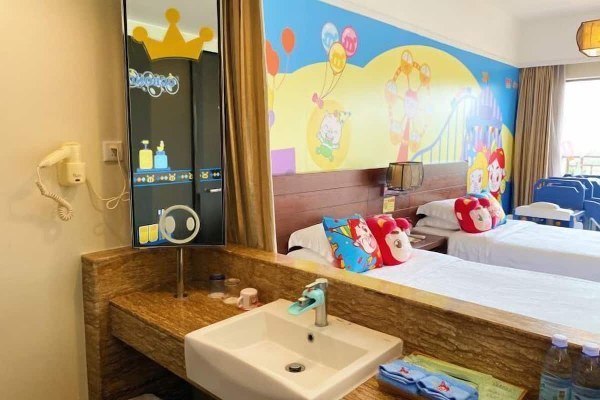 Ein Hotelzimmer mit einem großen Spiegel, einem Waschbecken, einem Bett mit bunten Kissen und einem Wandgemälde.