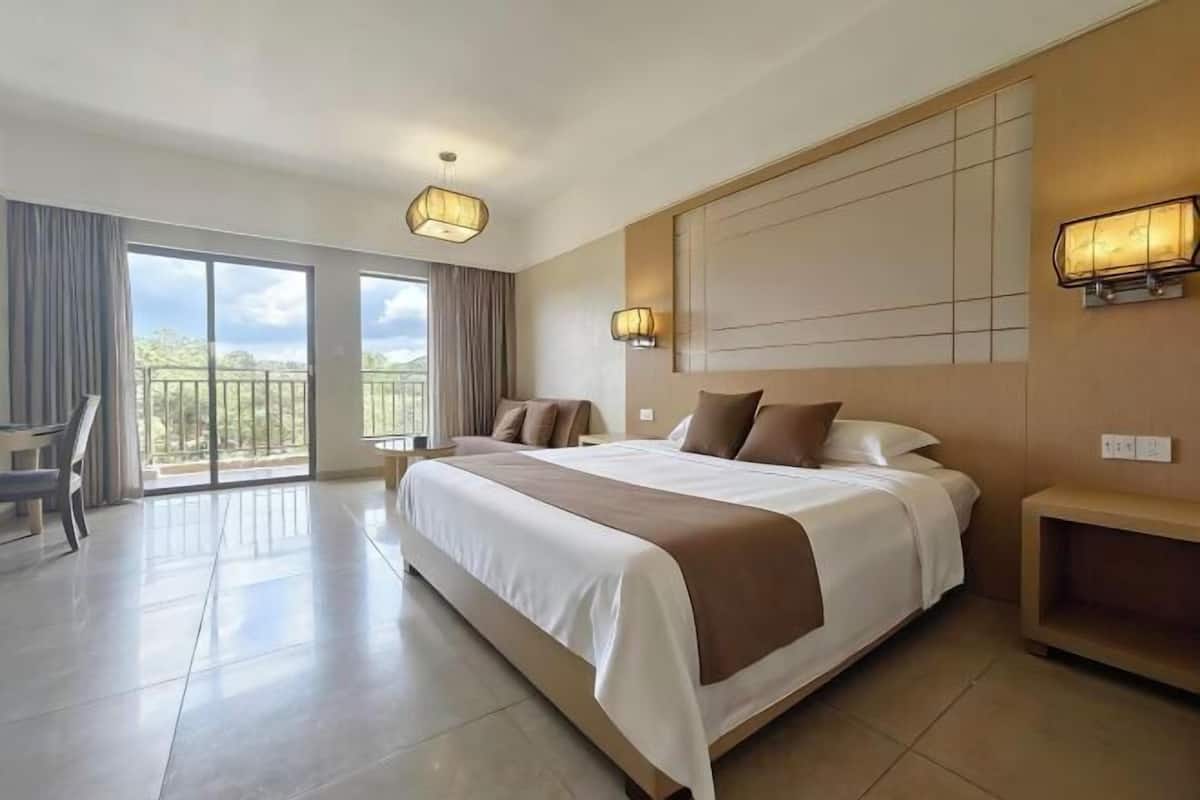 Ein geräumiges Hotelzimmer mit einem großen Bett, einem Schreibtisch und einem Balkon mit Aussicht.