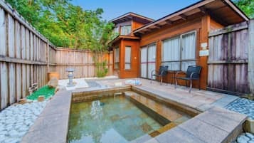 Une cabane en bois dotée d’un bain à remous, d’un espace extérieur aménagé et d’un sentier en pierre.