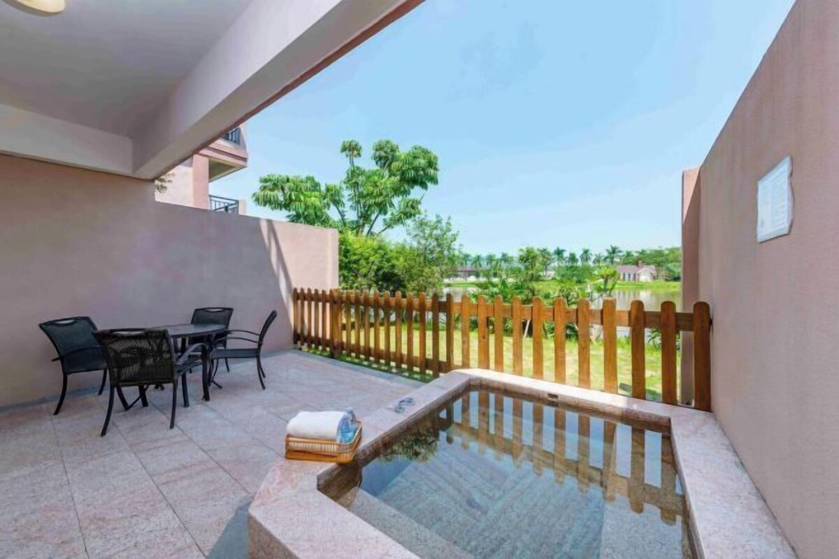 A patio with a pool, outdoor furniture, and a wooden fence.