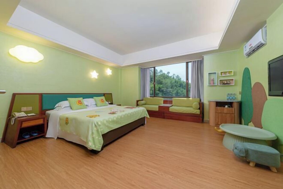 A hotel room with a bed, a sofa, a small table, and a TV.