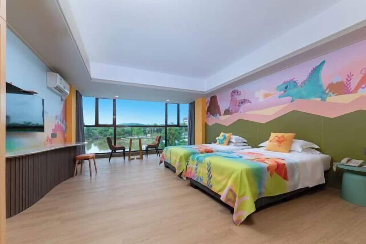 Ein Hotelzimmer mit einem großen Bett, einem Schreibtisch und Blick ins Freie.