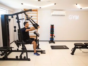 A gym with a weight bench, a squat rack, and a rack of dumbbells. - Ibis Serra Talhada (Serra Talhada)