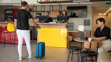 A hotel lobby with a reception desk, bar area, and seating.