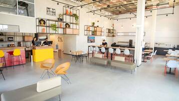 A modern interior with a reception desk, seating areas, and a kitchenette.