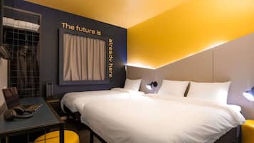 Una habitación de hotel moderna con una cama grande, un escritorio con una computadora portátil, una silla y un armario.