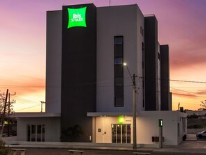 A modern building with a prominent green sign reading 'ibis Styles' on the facade.