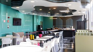 Un interior moderno con mesas y sillas, una zona de bar y un techo curvo con código binario.