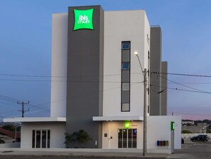 A modern building with a green sign reading 'ibis Styles' and a bar named 'Barretos' at the ground level. - Ibis Styles Barretos (Barretos)
