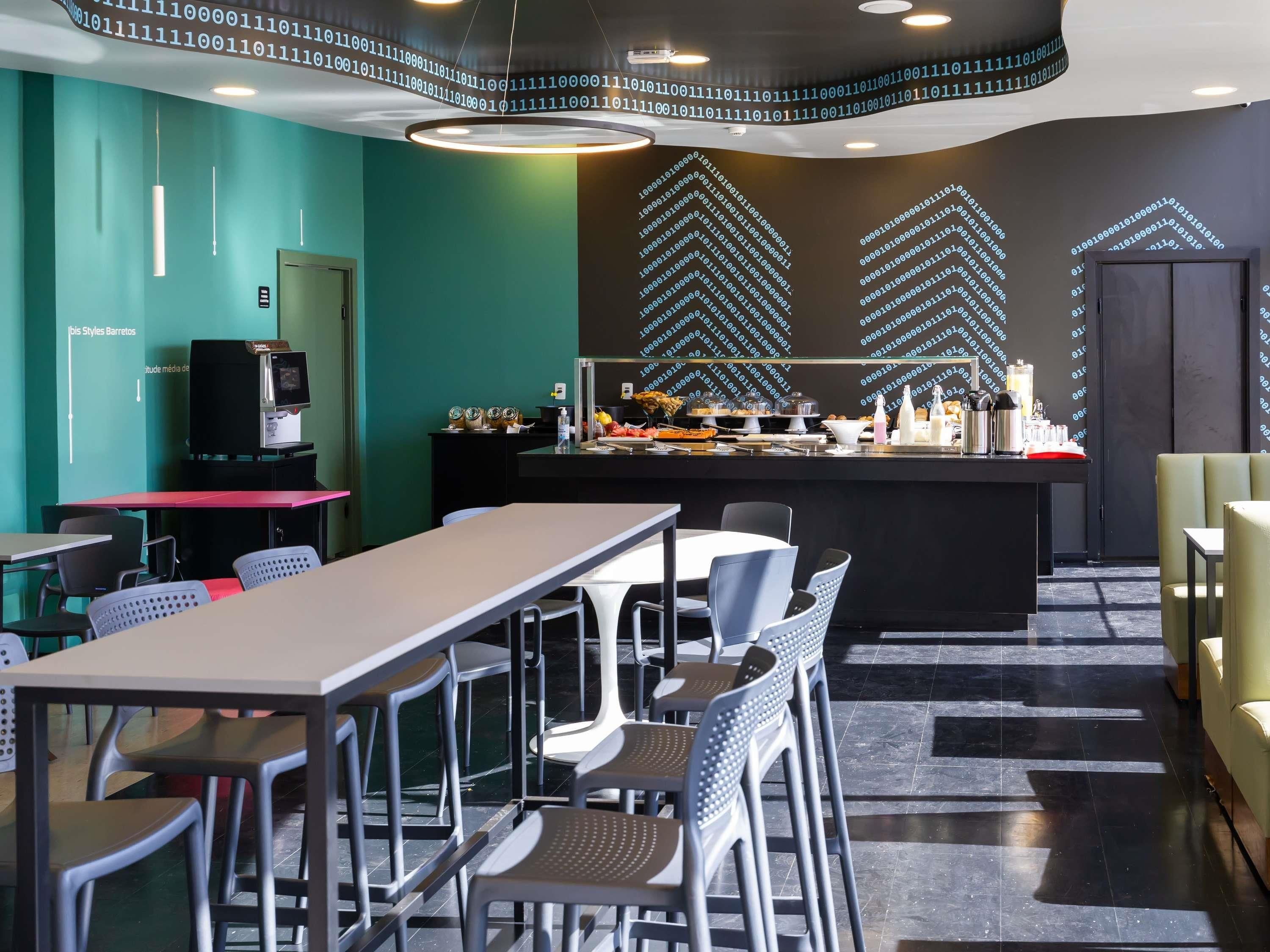 A modern dining area with a bar, seating, and a television.