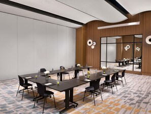 A conference room with a long table, chairs, and a patterned carpet. - Novotel Abidjan Marcory (Abidjan)