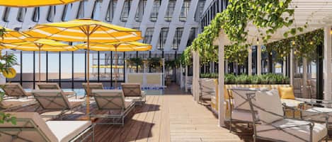 Una terrazza sul tetto con posti a sedere all'aperto, ombrelloni e un edificio moderno sullo sfondo.