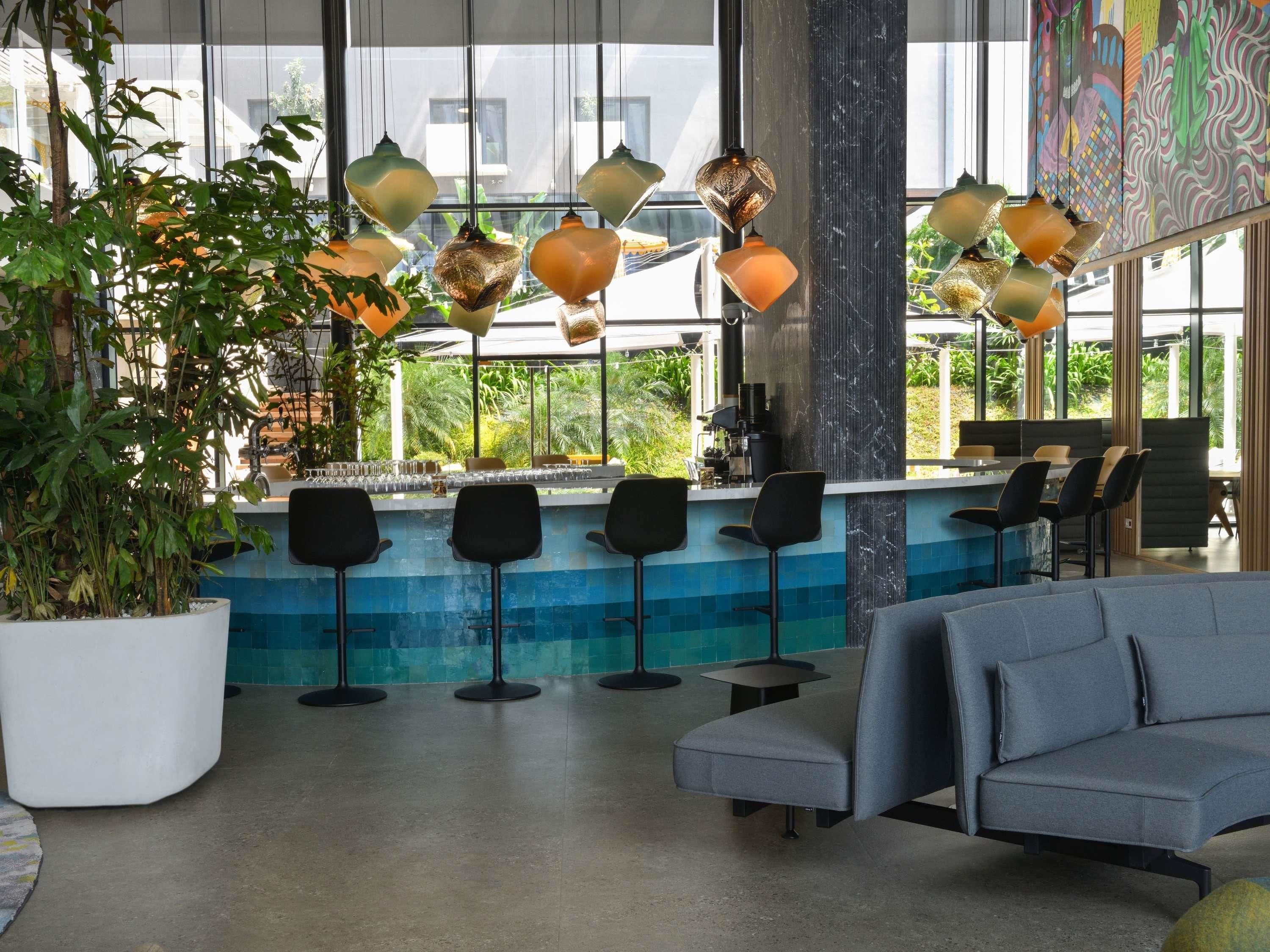 Een moderne bar met een zwembad, barstoelen en een bank.