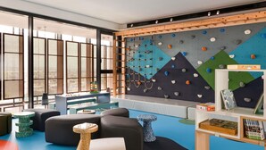 Ein Kinderspielbereich mit Kletterwänden, Sitzgelegenheiten und Lernspielzeug.