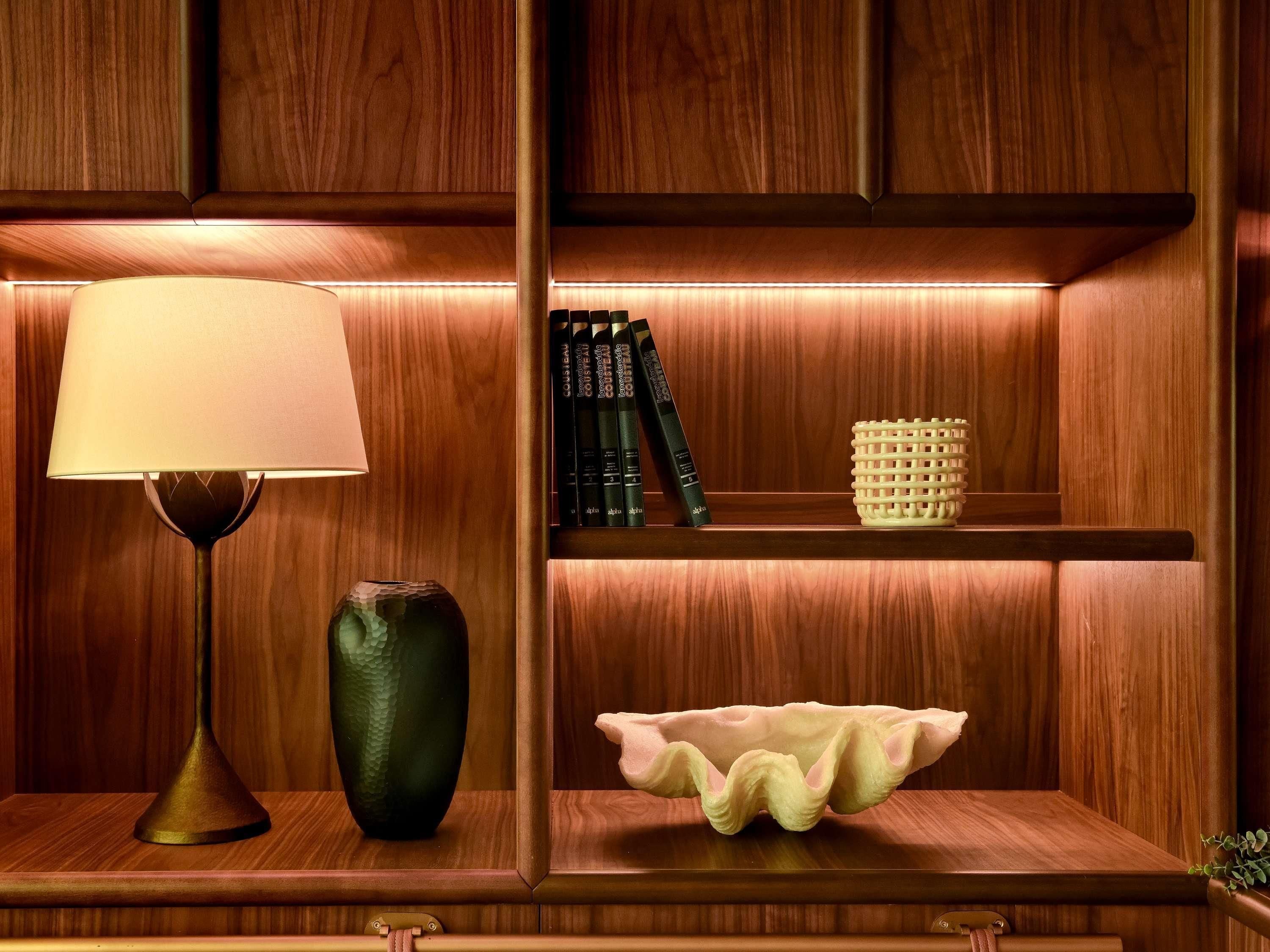 A wooden shelf with a lamp, books, and decorative items.