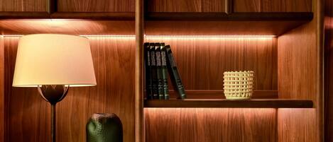 A wooden shelf with a lamp, books, and decorative items.