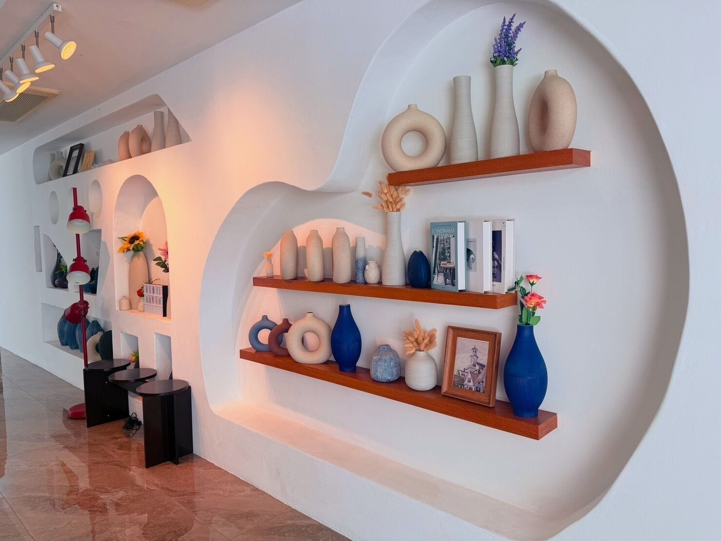 Un interior moderno con estanterías curvas que exhiben varios objetos decorativos.