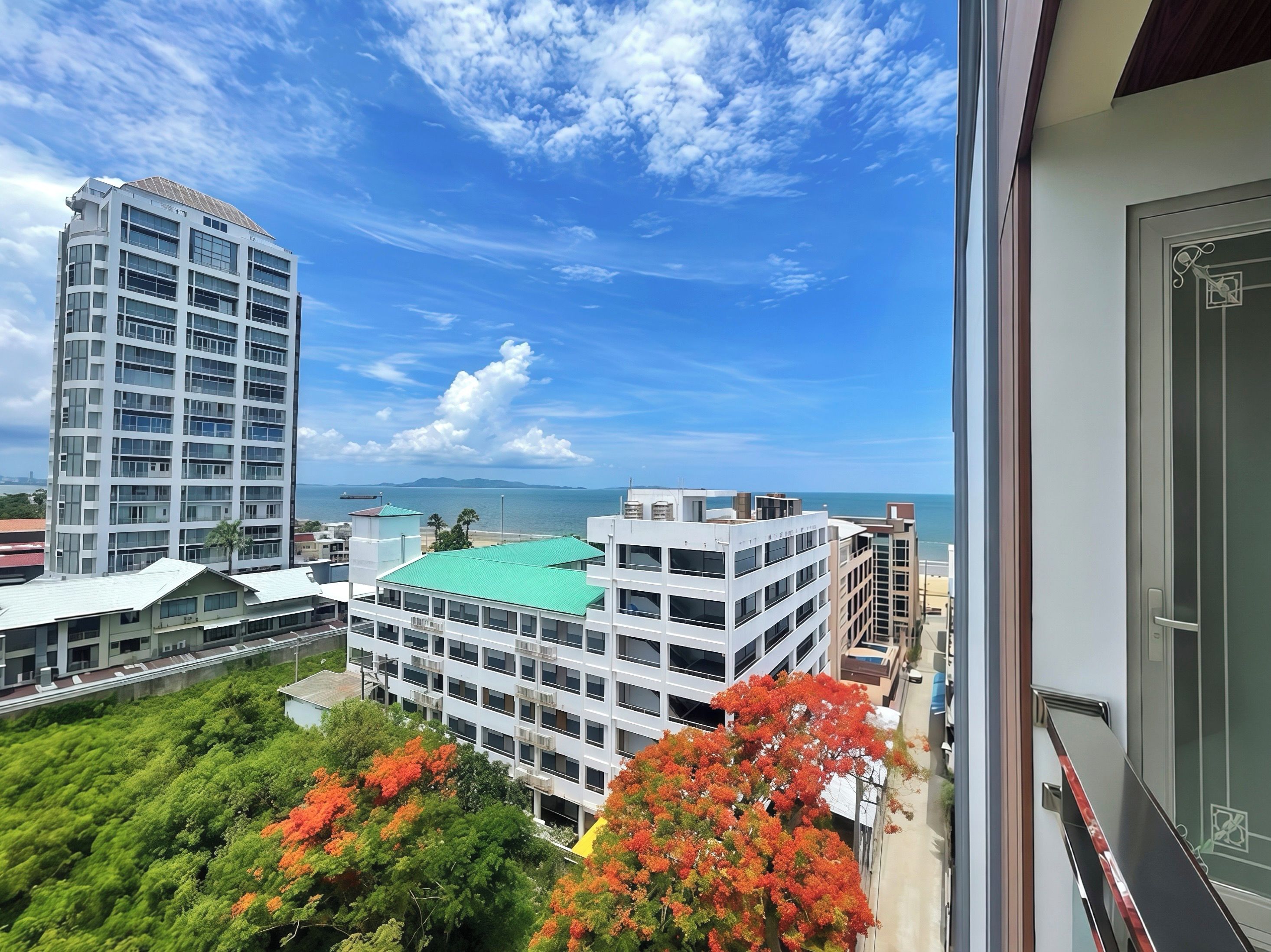 A high-rise building with a view of the sea and mountains in the distance.