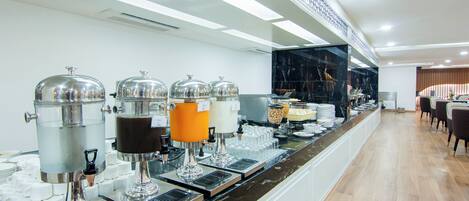 A buffet area with multiple beverage dispensers and a variety of food items.