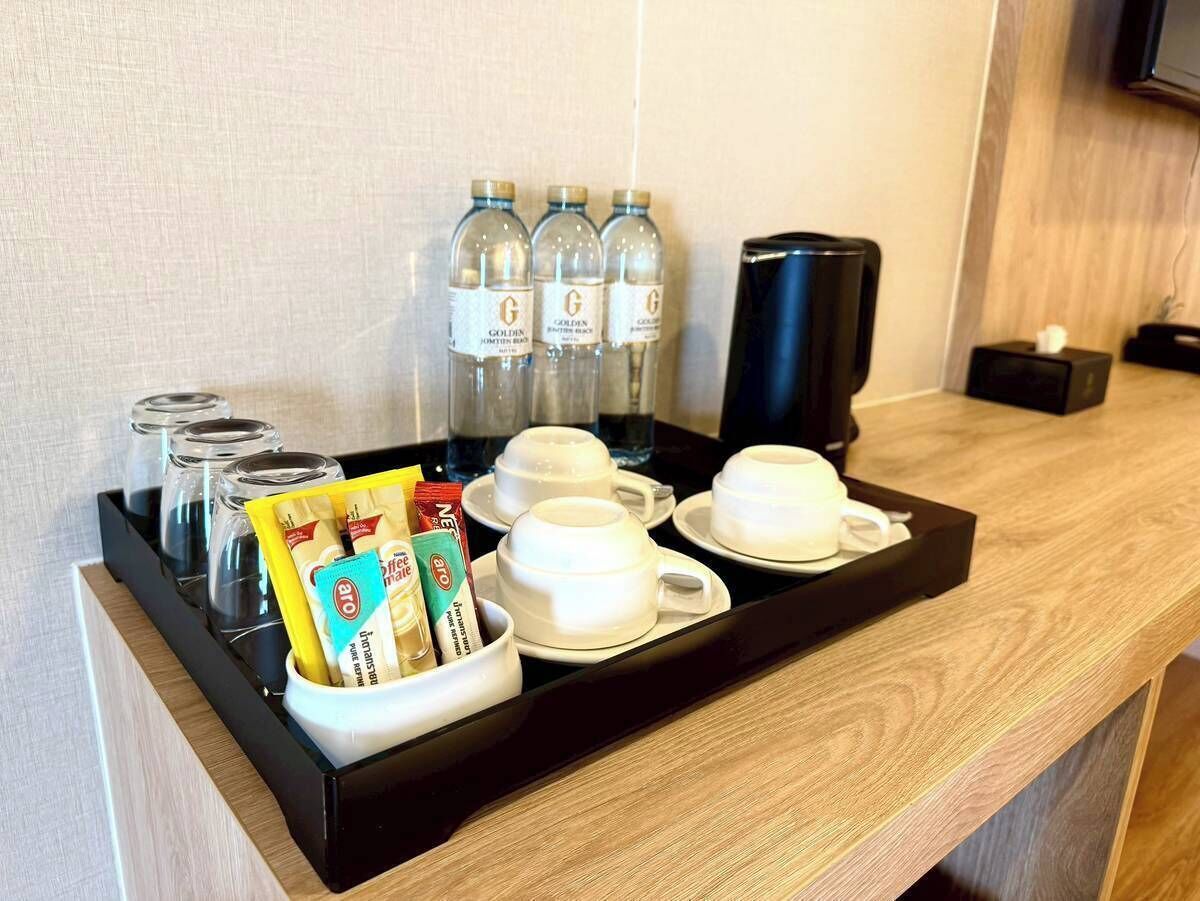 Ein Frühstücksbuffet im Hotelzimmer mit Kaffeetassen, Teebeuteln und Wasserflaschen.