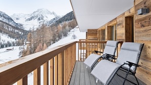 A wooden deck with two chairs and a view of snow-covered mountains. - Luxury Apartment, 2 Bedrooms Rahas B Grimentz - By Mrs Miggins (Grimentz)