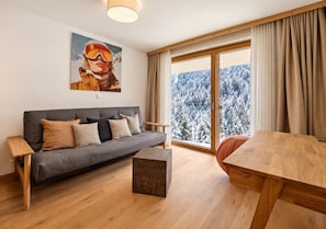 A modern living room with a sofa, a coffee table, and a dining table.