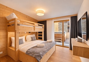 Ein Zimmer mit einem Holzbett, Schreibtisch und einem großen Fenster.