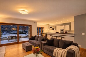 Salon chaleureux, coussins noirs et plaid beige