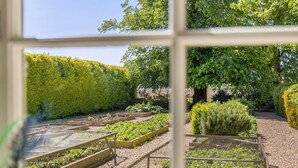Un jardin avec des plates-bandes surélevées et une grande variété de plantes.