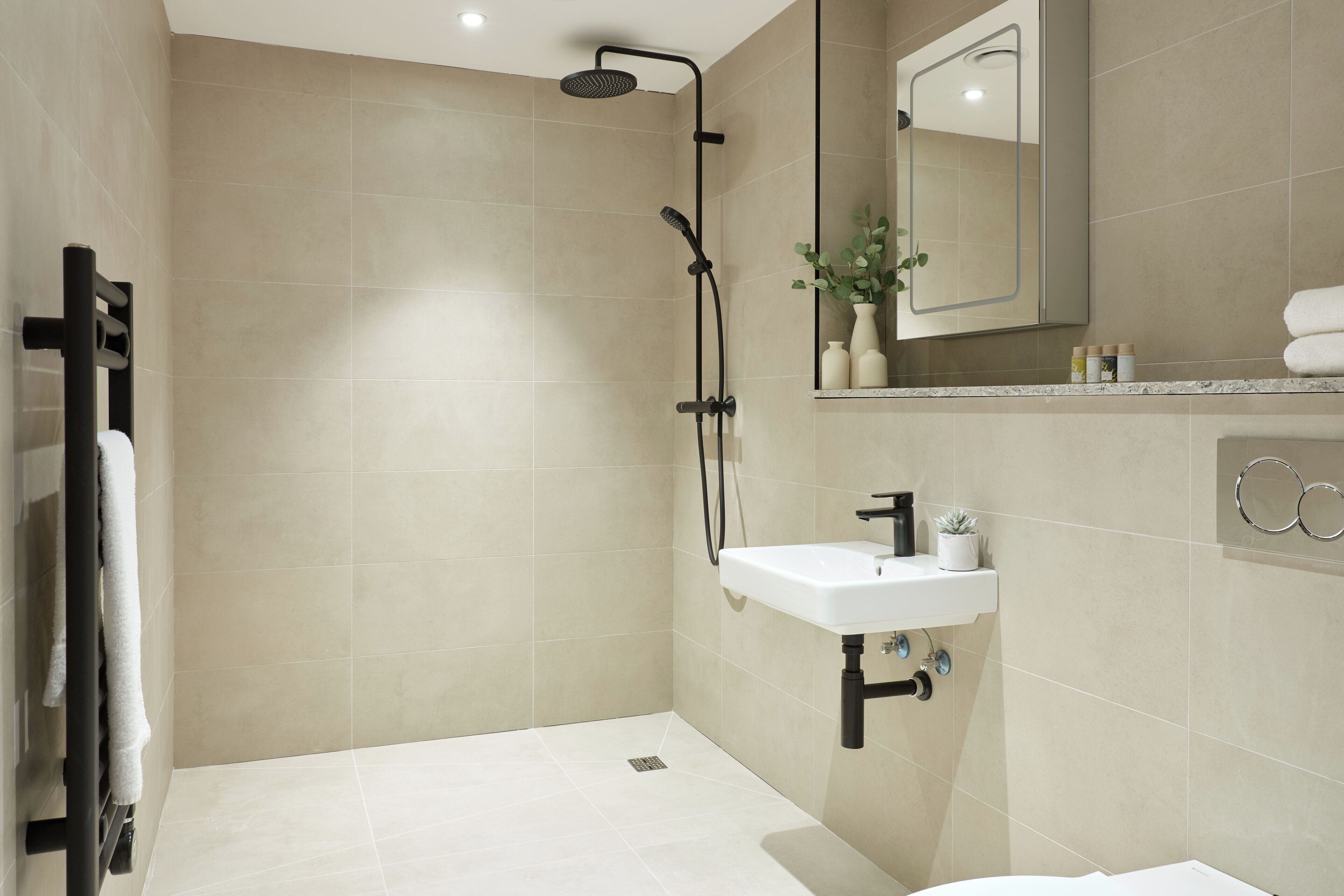 A modern bathroom with a shower, sink, and mirror.