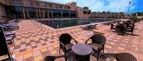 A poolside area with lounge chairs and a tiled deck.