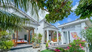 A traditional Vietnamese house with a garden, a bed, and a dining area. - BA DUNG VILLA Coffee (Phu Quy)
