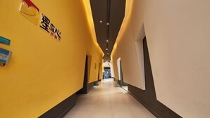A hotel corridor with yellow walls and a tiled floor. - Jinjiang Inn (Shanghai People's Square East Huaihai Road) (Shanghai)