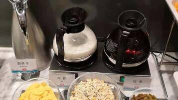 A coffee station with two coffee makers and three bowls of different food items.