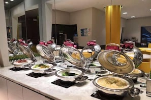 A buffet with multiple food stations, each with a covered serving dish. - Jinjiang Inn (Shanghai People's Square East Huaihai Road) (Shanghai)