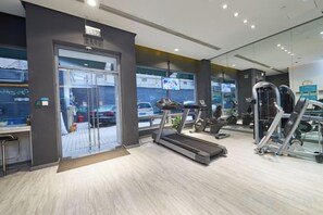 A gym with exercise equipment, a treadmill, and a door leading to the outside. - Jinjiang Inn (Shanghai People's Square East Huaihai Road) (Shanghai)