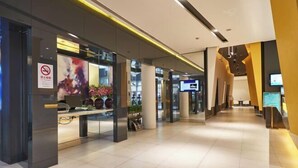 A modern hotel corridor with a reception desk, a no-smoking sign, and a digital screen displaying information. - Jinjiang Inn (Shanghai People's Square East Huaihai Road) (Shanghai)
