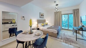 A modern hotel room with a dining area, a bed with a view, and a balcony. - Comfy Studio Apartment in DIFC (DIFC)