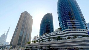 A modern urban skyline with two prominent curved skyscrapers and a high-rise building in the background. - Comfy Studio Apartment in DIFC (DIFC)