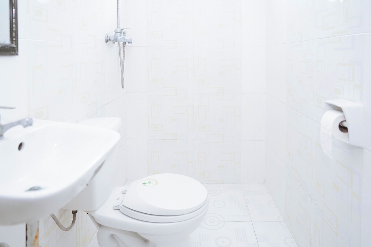 A bathroom with a toilet, sink, and shower.