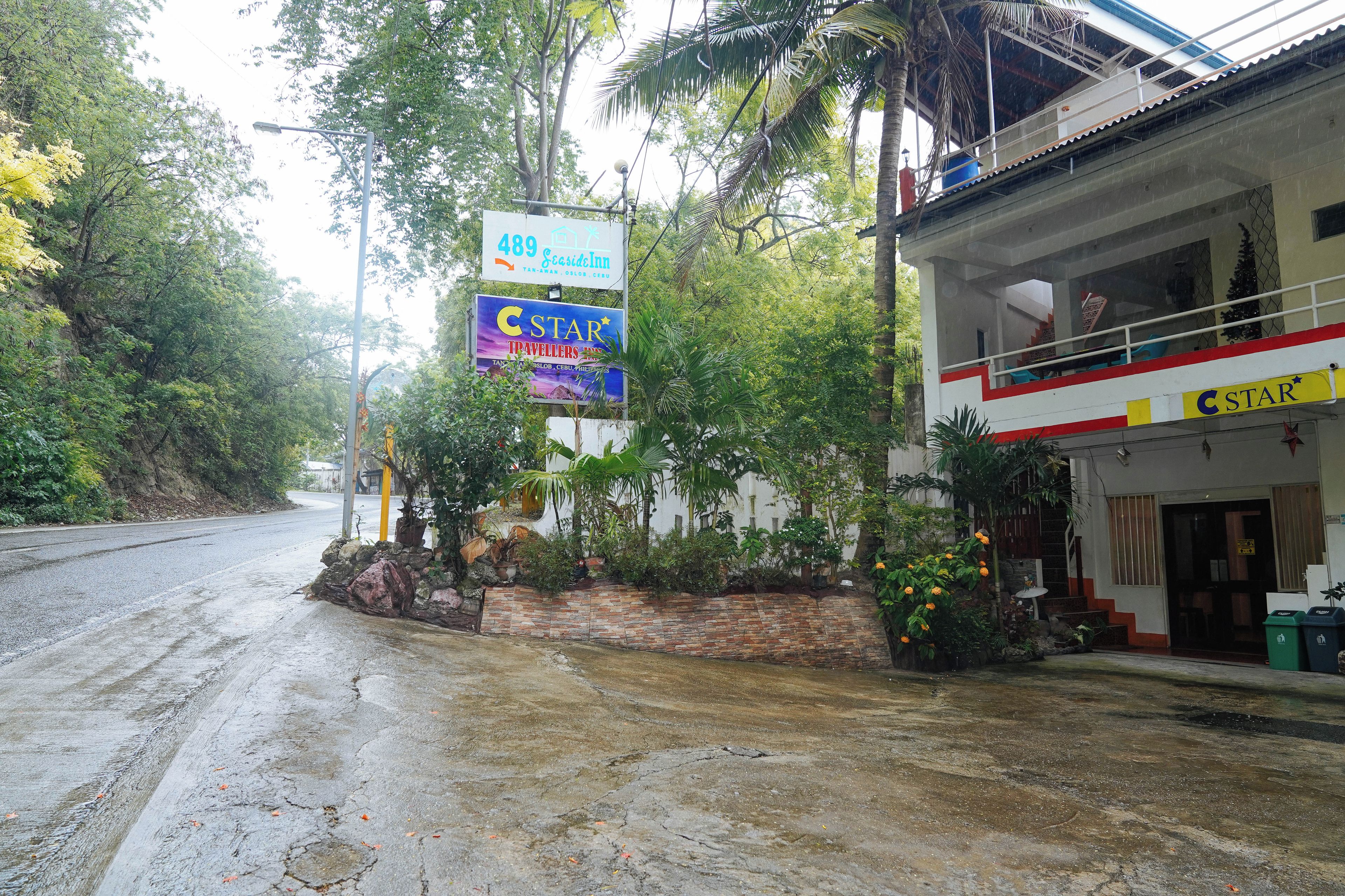 A hotel with a signboard advertising '489 Eco Inn' and 'C Star Travellers'.