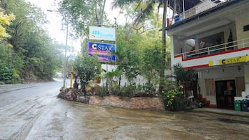 A hotel with a signboard advertising '489 Eco Inn' and 'C Star Travellers'.