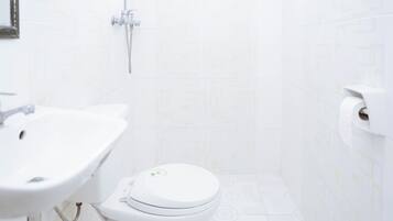 Un baño con inodoro, lavamanos y ducha.